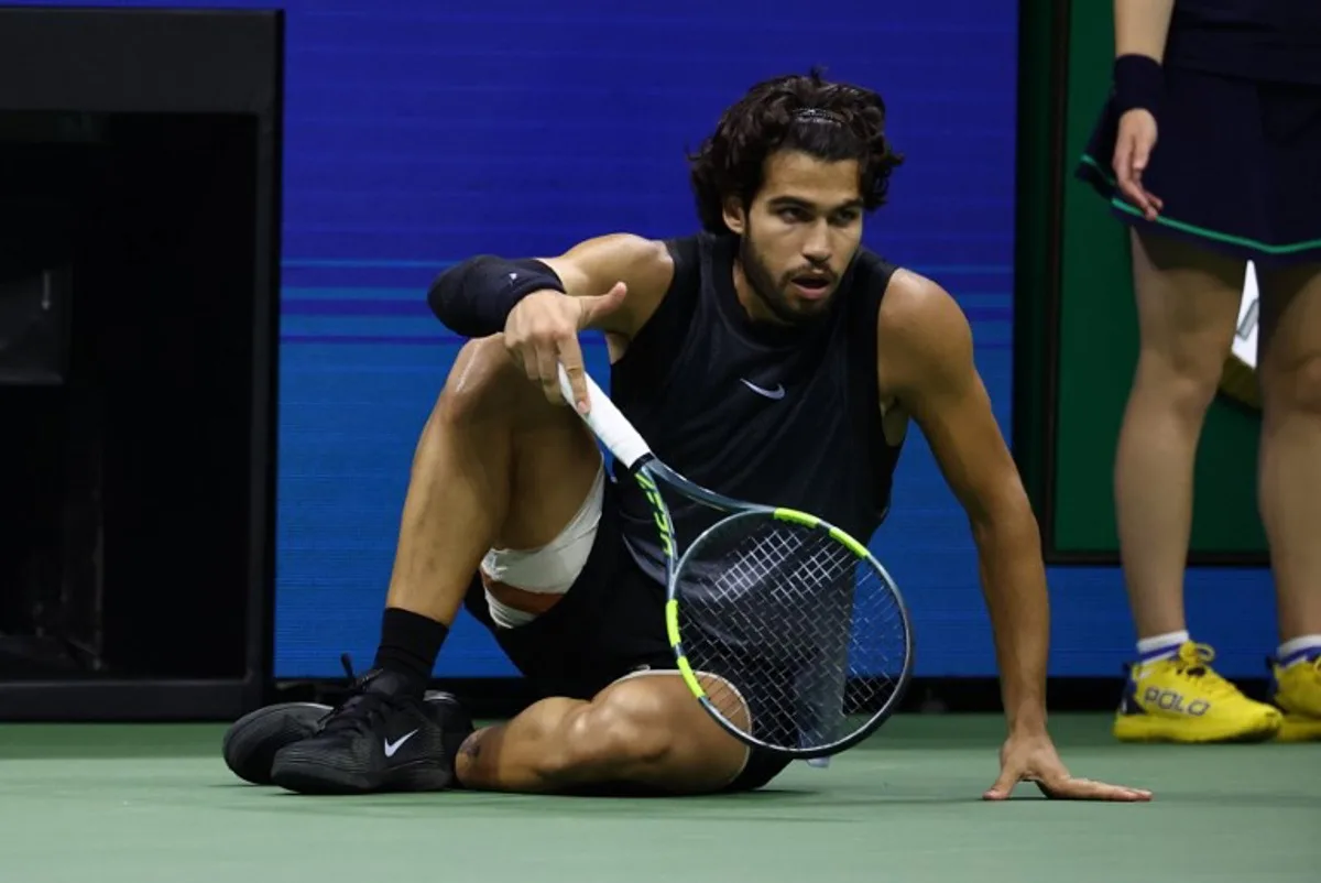 Spain's Carlos Alcaraz recovers after falling during the men's singles quarter-final tennis match against USA's Ben Shelton on day ten of the US Open tennis tournament at the USTA Billie Jean King National Tennis Center in New York City on September 9, 2026.  Leonardo MUNOZ / AFP
