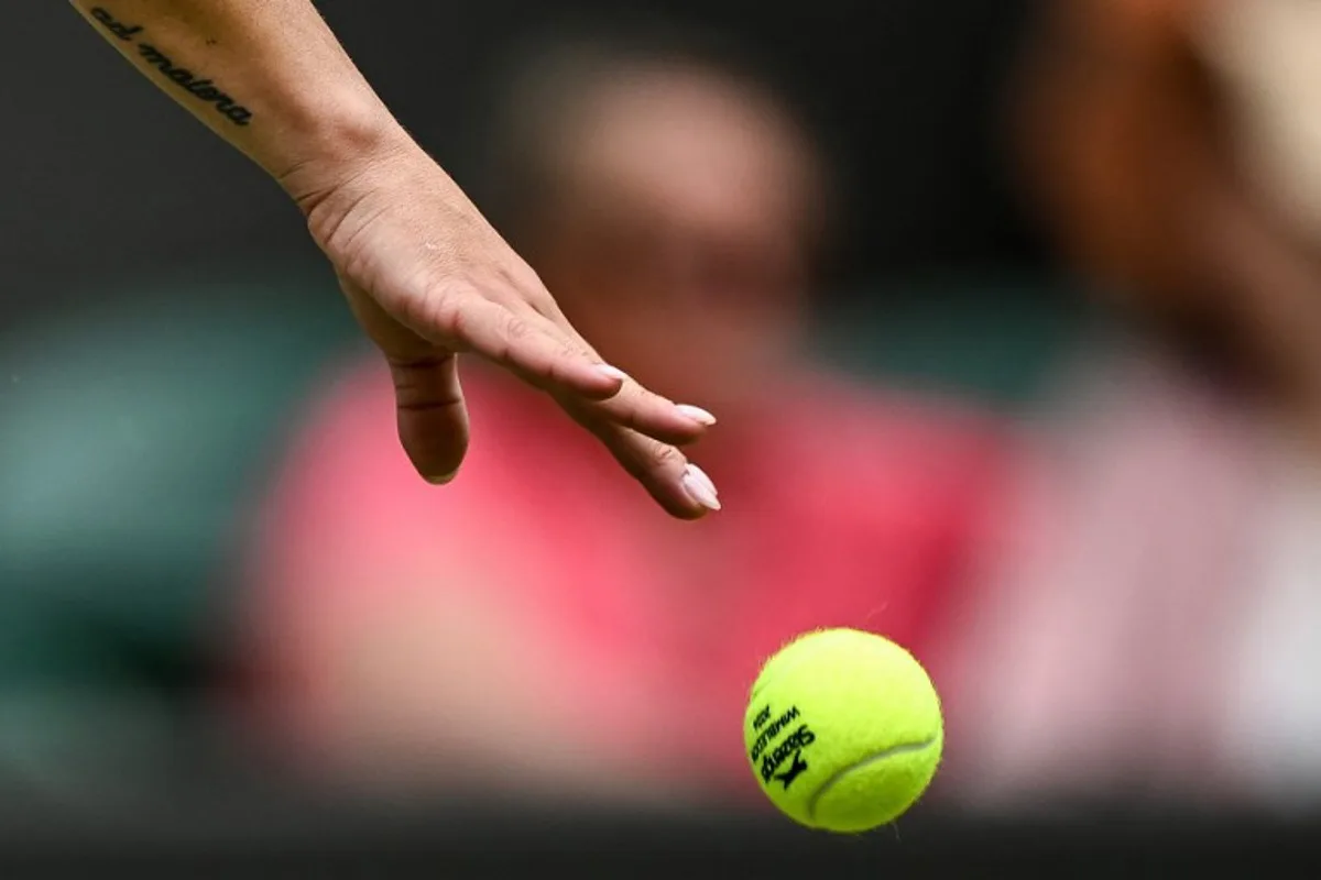 The tatoo of Italy's Martina Trevisan reading "A Maiora" in Latin (which translates as "Towards greater things" in English) is pictured on her arm as she bounces the ball prior to serve against US player Madison Keys during their Women's singles tennis match on the first day of the 2024 Wimbledon Championships at The All England Lawn Tennis and Croquet Club in Wimbledon, southwest London, on July 1, 2024.  Ben Stansall / AFP