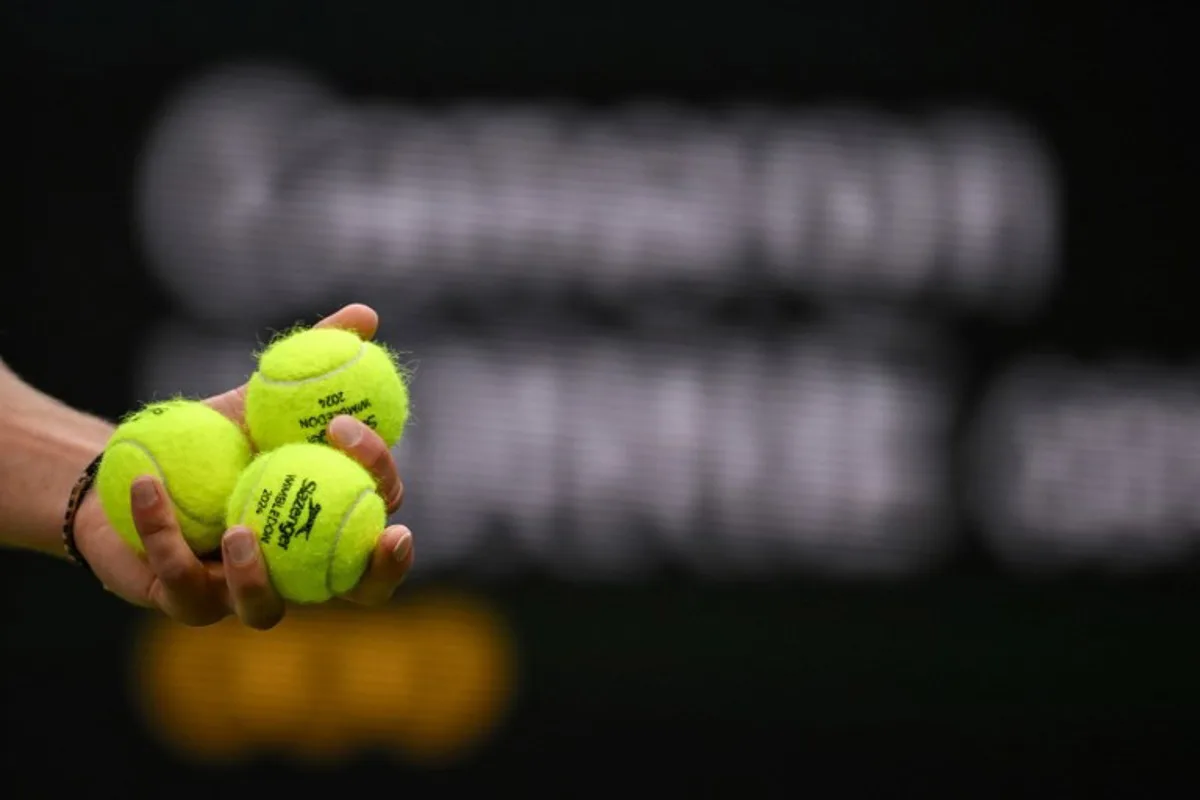 Germany's Alexander Zverev holds tennis balls as he prepares to serve to Britain's Cameron Norrie during their men's singles tennis match on the sixth day of the 2024 Wimbledon Championships at The All England Lawn Tennis and Croquet Club in Wimbledon, southwest London, on July 6, 2024.  ANDREJ ISAKOVIC / AFP