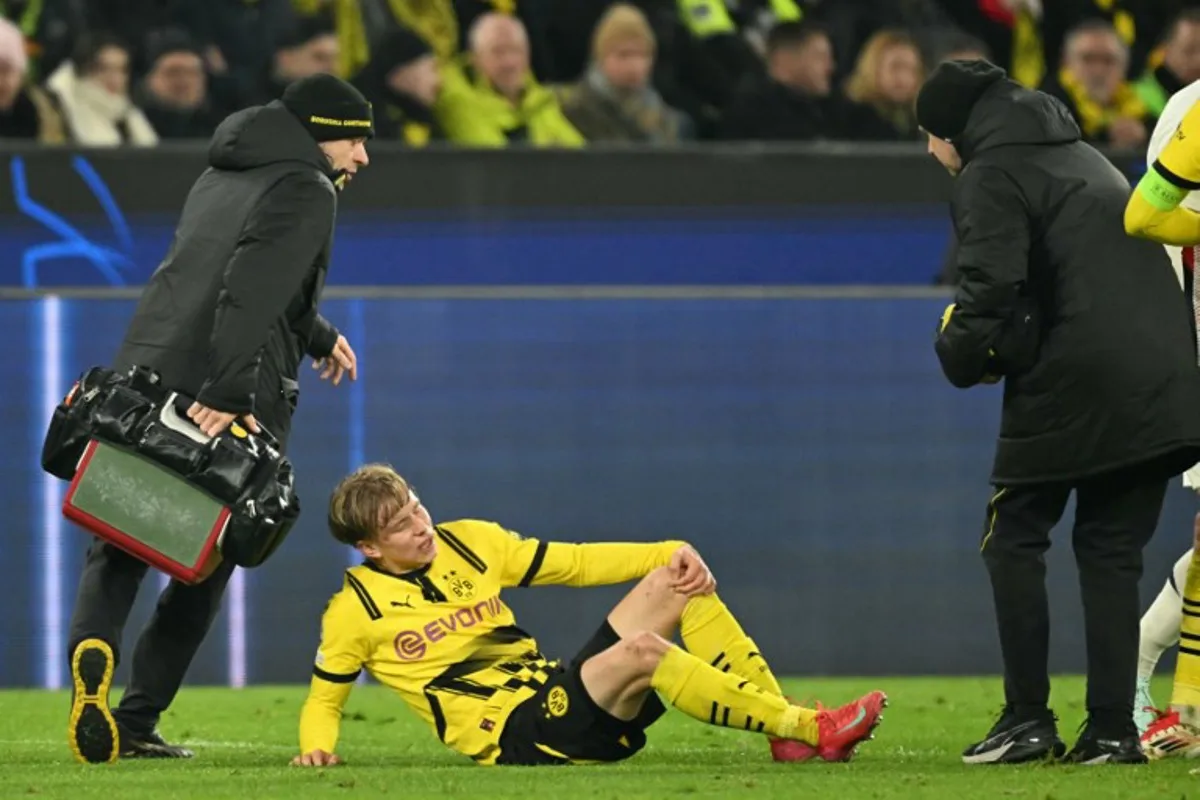 Dortmund's Swedish defender #24 Daniel Svensson receives medical attention after picking up an injury during the UEFA Champions League last 16, first leg football match between Borussia Dortmund and OSC Lille in Dortmund, western Germany, on March 4, 2025.  INA FASSBENDER / AFP