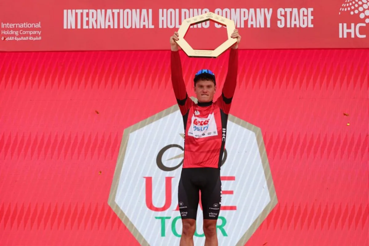 Lotto-DSTNY's Belgian cyclist Lennert Van Eetvelt lifts his trophy after winning the race of the 6th UAE Cycling Tour on February 25, 2024.  Giuseppe CACACE / AFP