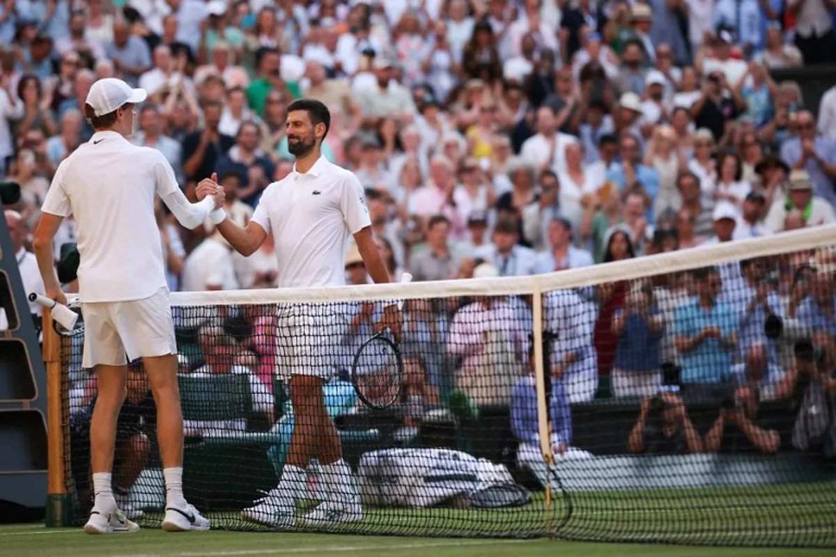 Italy's Jannik Sinner (L) shakes hands with Serbia's Novak Djokovic after winning their men's singles semi-final tennis match on the twelfth day of the 2025 Wimbledon Championships at The All England Lawn Tennis and Croquet Club in Wimbledon, southwest London, on July 11, 2025. HENRY NICHOLLS / AFP