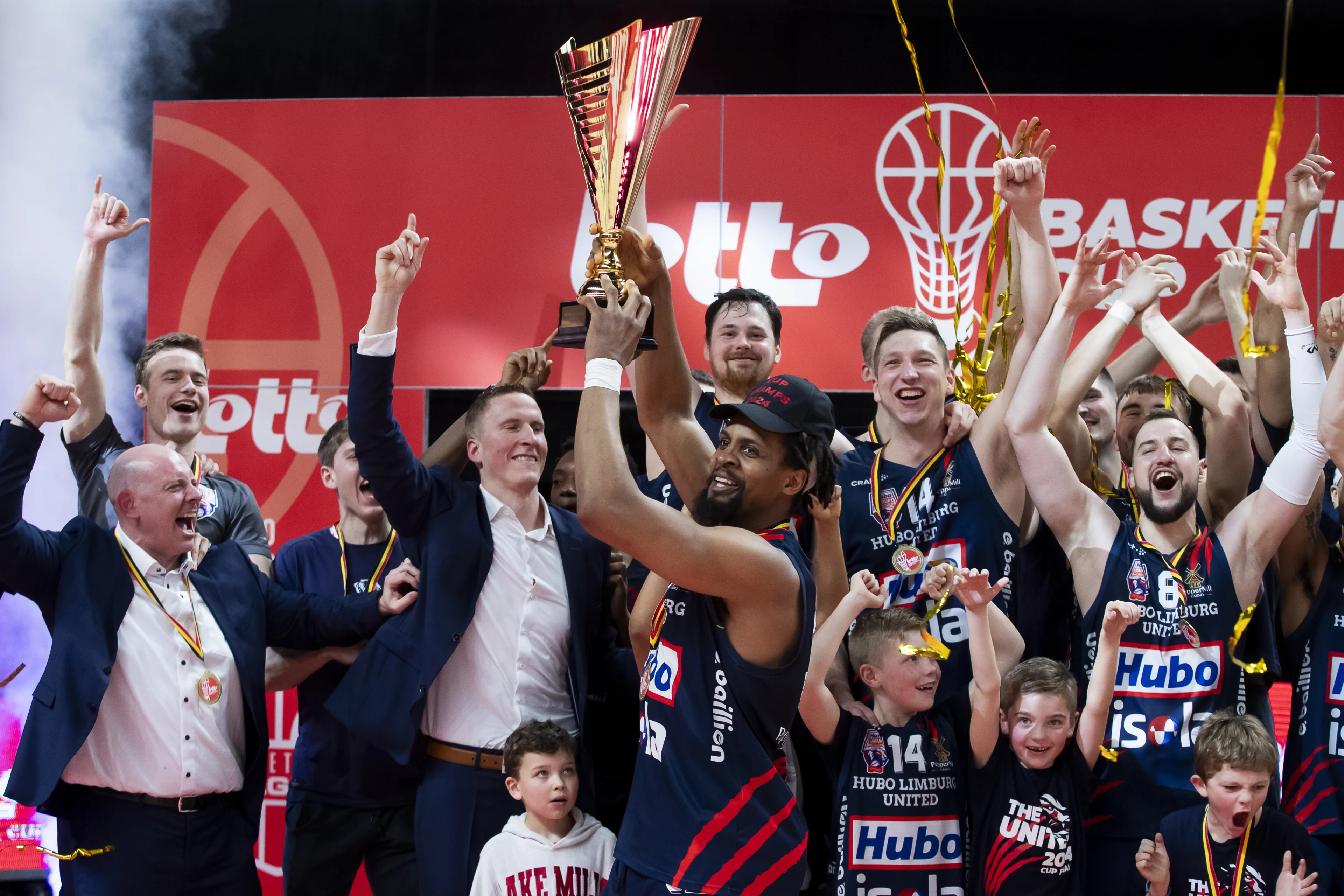 Limburg's Clifford Hammonds holds the trophy and celebrates with teammates after winning a basketball match between Spirou Charleroi and Limburg United, Sunday 10 March 2024 in Brussels, the final of the men's Belgian Basketball Cup. BELGA PHOTO KRISTOF VAN ACCOM