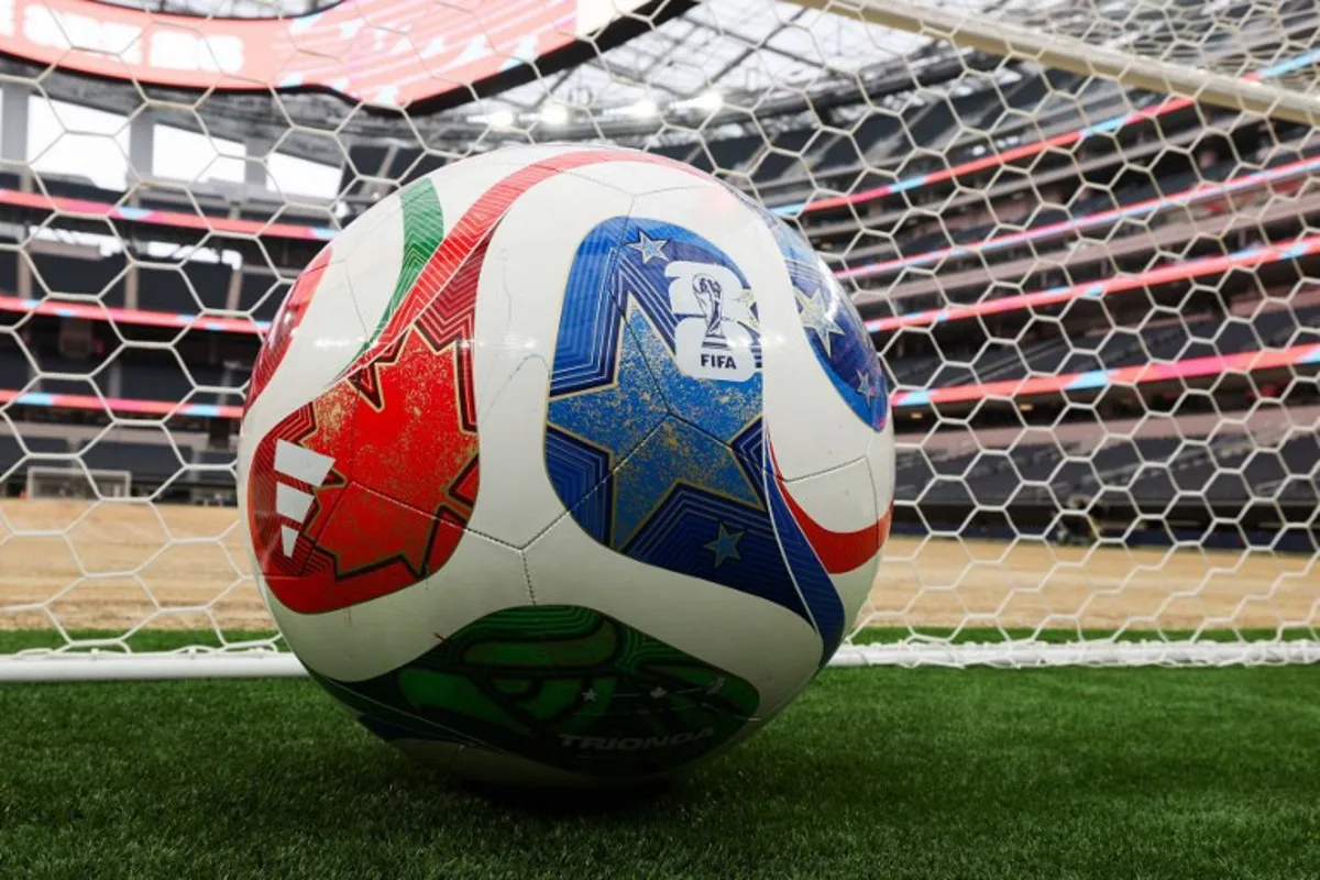 A giant ball is displayed behind a goal as an expanded pitch surface area, which required the removal of corner seating and a raised custom field platform, awaits the installation of grass during the 30 Days to FIFA World Cup 2026 media event at SoFI Stadium before the pitch installation and temporary renaming to Los Angeles Stadium in Inglewood, California on May 12, 2026. The US Men's National Team will play their first 2026 FIFA World Cup match on June 12 against Paraguay. Patrick T. Fallon / AFP