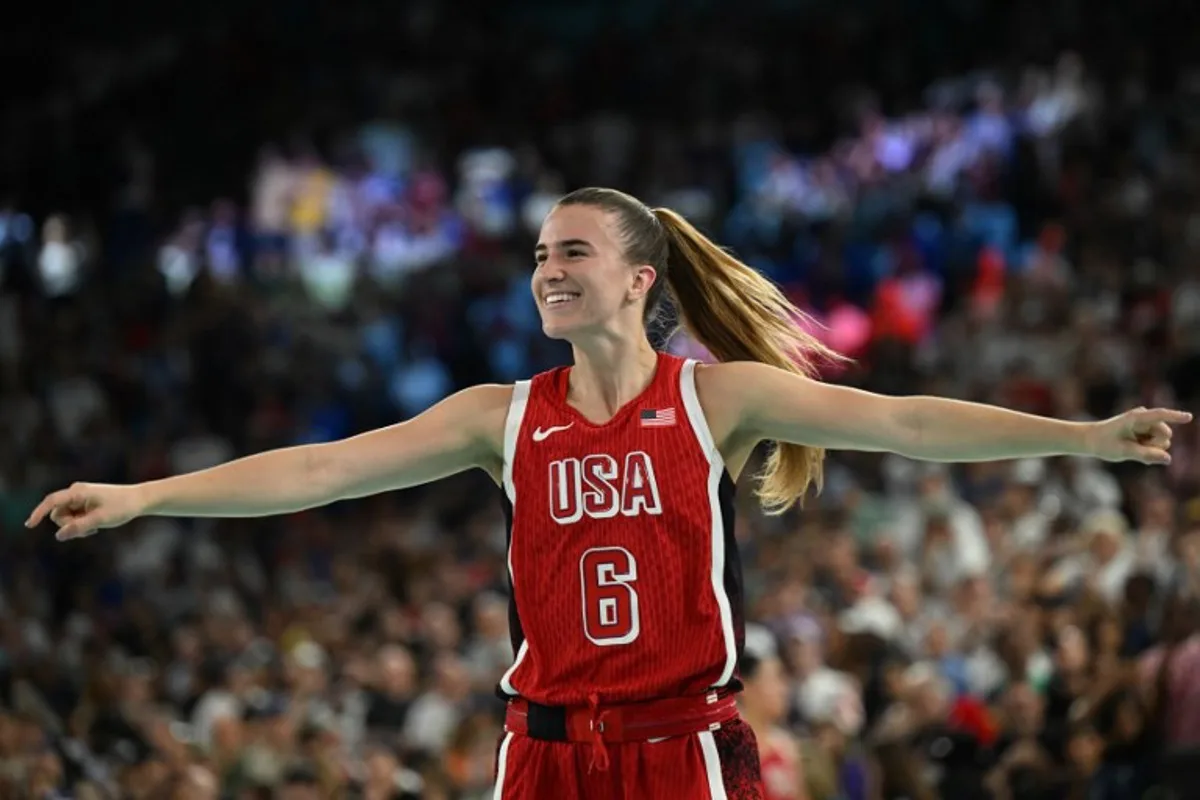 USA's #06 Sabrina Ionescu celebrates after the USA won the women's Gold Medal basketball match between France and the USA during the Paris 2024 Olympic Games at the Bercy  Arena in Paris on August 11, 2024.  Paul ELLIS / AFP