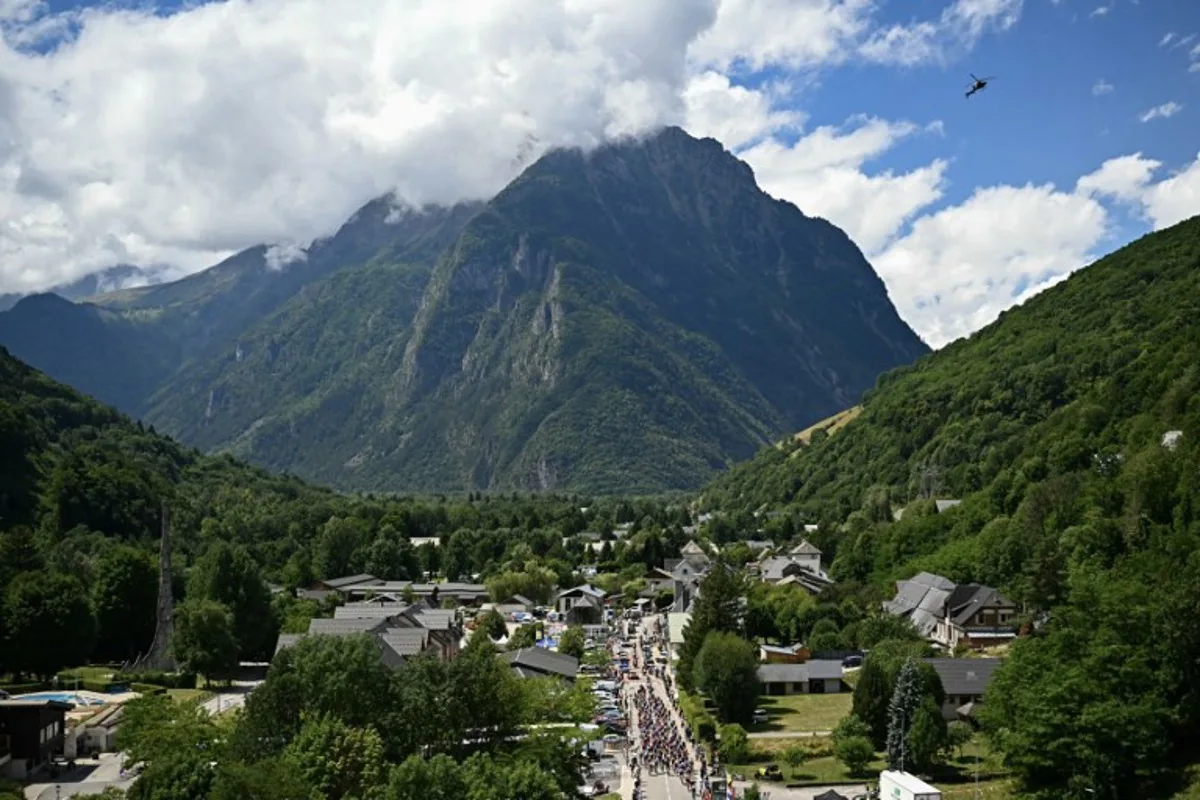 The pack of riders (peloton) cycles during the 18th stage of the 112th edition of the Tour de France cycling race, 171.5 km between Vif and Courchevel Col de la Loze, in the Alps, southeastern France, on July 24, 2025. Loic VENANCE / AFP