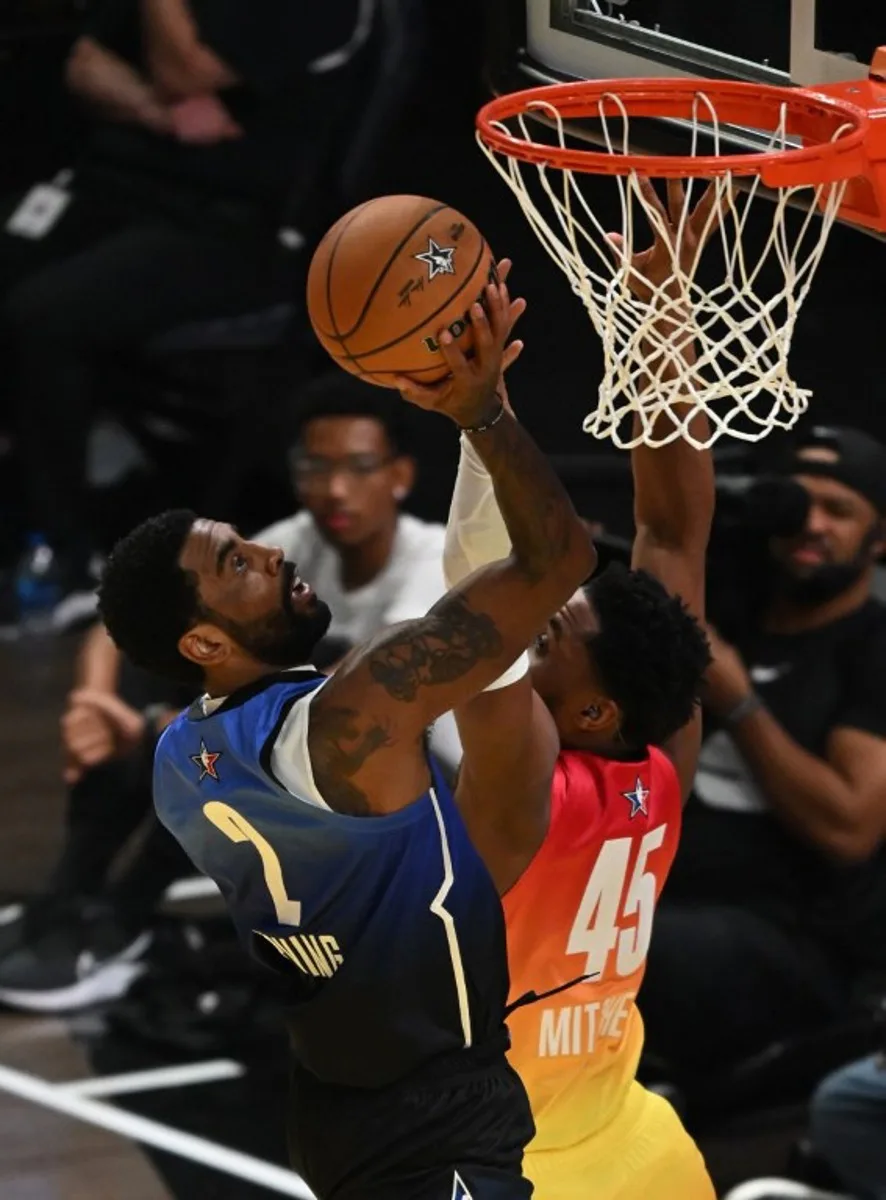 Dallas Mavericks' Kyrie Irving (L) and Cleveland Cavaliers' Donovan Mitchell (R) fight for the ball during the NBA All-Star game between Team Giannis and Team LeBron at the Vivint arena in Salt Lake City, Utah, February 19, 2023.   Patrick T. Fallon / AFP