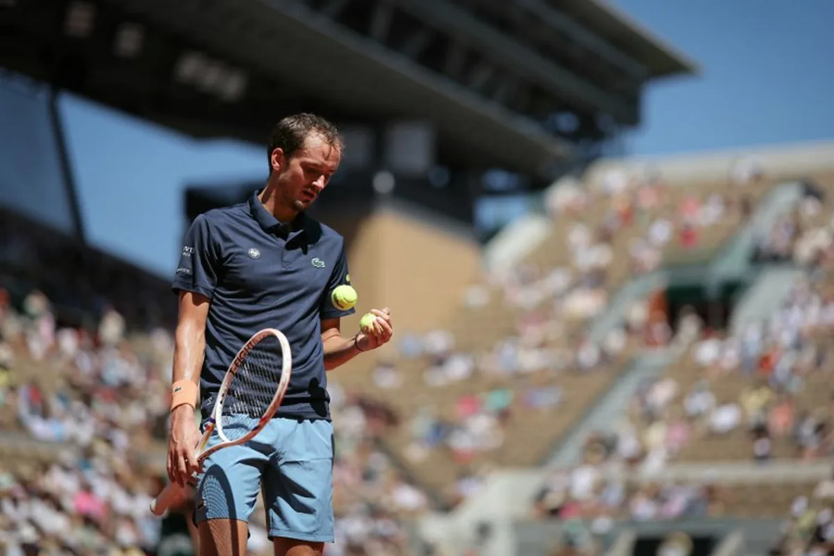 Daniil Medvedev selects a ball as he prepares to serve to Australia's Adam Walton during their men's singles match on day 3 of the French Open tennis tournament on Court Suzanne-Lenglen at the Roland-Garros Complex in Paris on May 26, 2026. Thomas SAMSON / AFP