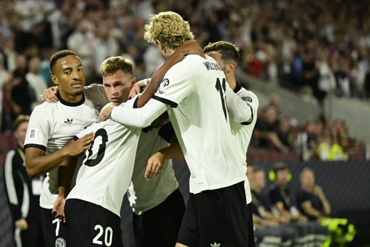 Germany's midfielder #20 Serge Gnabry (2nd L) celebrates with team players after scoring the opening 1-0 goal during the 2026 World Cup qualifiers Europe zone group A football match between Germany and Northern Ireland on September 7, 2025 in Cologne, western Germany. INA FASSBENDER / AFP