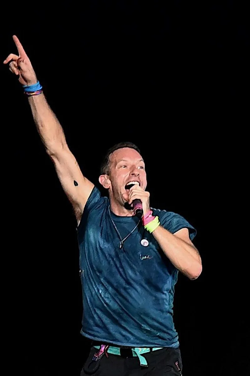 Musician Chris Martin of the British rock band Coldplay, performs onstage during a concert as part of their Music of the Spheres World Tour, at the D.Y. Patil stadium in Navi Mumbai on January 18, 2025.   SUJIT JAISWAL / AFP