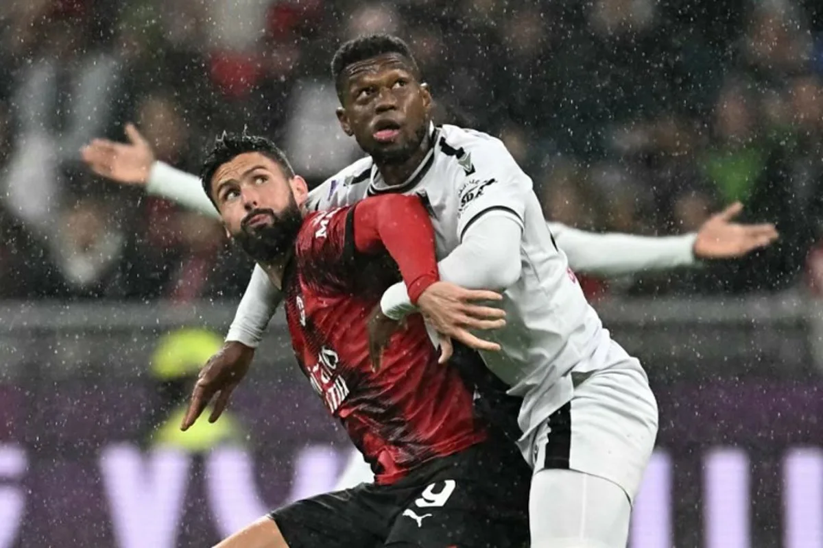 AC Milan's French forward #09 Olivier Giroud (L) fights for the ball with Udinese's Belgian defender #27 Christian Kabasele during the Italian Serie A football match between AC Milan and Udinese at San Siro stadium in Milan, on November 04, 2023.  GABRIEL BOUYS / AFP