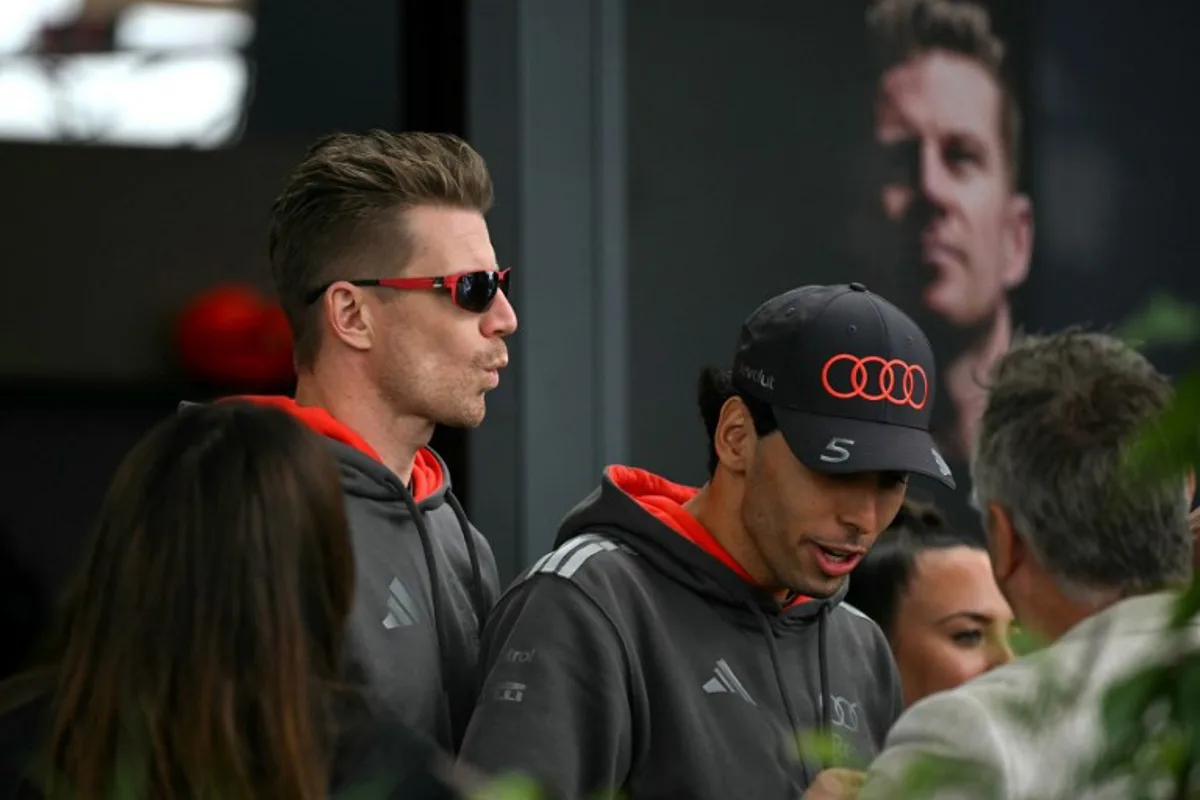Audi's German driver Nico Hulkenberg (L) and Audi's Brazilian driver Gabriel Bortoleto (C) walk through the paddock ahead of the third practice session of the Formula One Australian Grand Prix at the Albert Park Circuit in Melbourne on March 7, 2026. Paul Crock / AFP