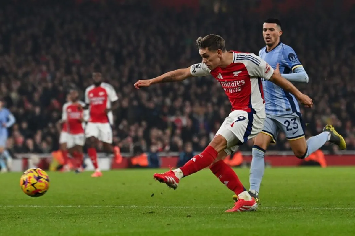 Arsenal's Belgian midfielder #19 Leandro Trossard shoots and scores his team second goal during the English Premier League football match between Arsenal and Tottenham Hotspur at the Emirates Stadium in London on January 15, 2025.   Glyn KIRK / AFP