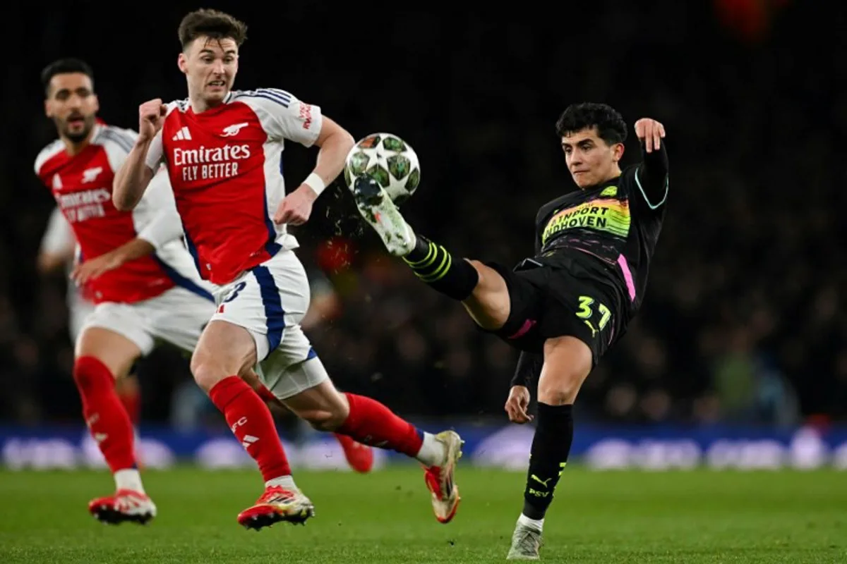 PSV Eindhoven's American midfielder #37 Richard Ledezma (R) controls the ball during the last 16 second leg UEFA Champions League football match between Arsenal and PSV Eindhoven at the Emirates Stadium in north London on March 12, 2025.  Glyn KIRK / AFP