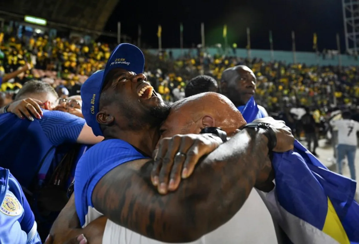 Curaçao fans celebrate World Cup 2026 qualification after a 0-0 draw with Jamaica at the National Stadium in Kingston, Jamaica on November 18, 2025. The tiny Caribbean nation of Curacao became the smallest country ever to qualify for the World Cup on November 18 as Haiti booked their return to the tournament for the first time in 52 years along with Panama. A nerve-shredding finale to the CONCACAF qualifying campaign saw Curacao -- with a population of just 156,000 -- squeeze into next year's finals in the United States, Canada and Mexico with a 0-0 draw against Jamaica in Kingston.  Ricardo MAKYN / AFP