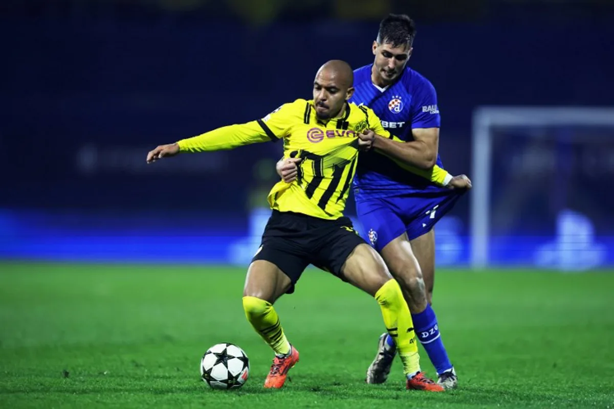 Borussia Dortmund's Dutch forward #21 Donyell Malen (L) fights for the ball with Dinamo Zagreb's Spanish defender #04 Raul Torrente   during the UEFA Champions League, League phase - Matchday 5, football match between GNK Dinamo Zagreb and Borussia Dortmund at the Maksimir Stadium in Zagreb, on November 27, 2024.  Damir SENCAR / AFP