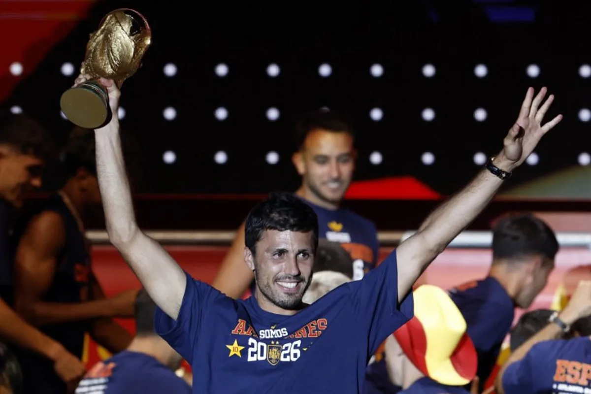 Spain's captain Rodri raises the World Cup trophy as he celebrates with teammates on a stage at Cibeles Square in Madrid on July 20, 2026, one day after winning their second World Cup title following a 1-0 victory against Argentina. Spain's World Cup winners come back home to a heroes' welcome in Madrid, where a million fans are expected to greet them after a night of raucous celebrations across the country. Oscar DEL POZO / AFP