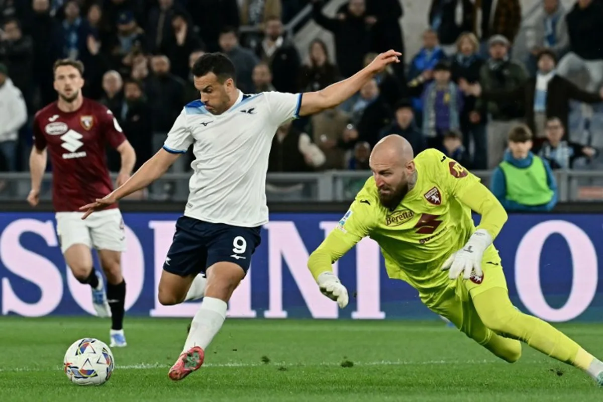 Lazio's Spanish forward #09 Pedro Rodriguez (L) shoots towards goal as Torino's Serbian goalkeeper #32 Vanja Milinkovic-Savic (R) dives to block it during the Italian Serie A football match between Lazio and Torino at the Olympic Stadium in Rome on March 31, 2025. Filippo MONTEFORTE / AFP