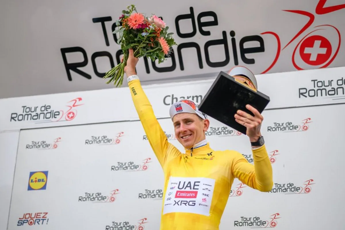 UAE Team Emirates-XRG's Slovenian rider Tadej Pogacar wearing the overall leader's yellow jersey celebrates during the podium ceremony after winning the fourth stage of the Tour of Romandie UCI cycling World tour, 149.6 km from Broc and to Charmey, in Charmey, Switzerland, on May, 2, 2026.  Fabrice COFFRINI / AFP