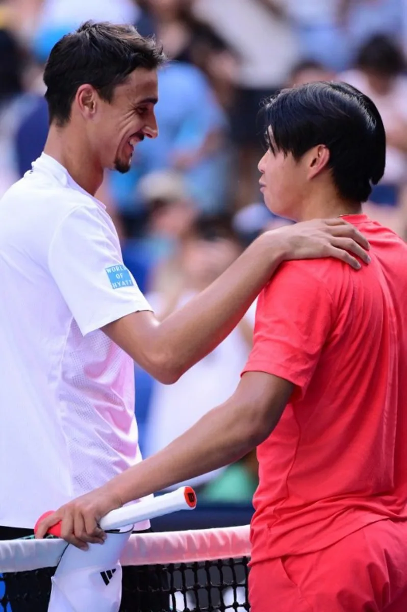 Italy's Lorenzo Sonego (L) speaks with USA's Learner Tien after Sonego's victory in their men's singles match on day nine of the Australian Open tennis tournament in Melbourne on January 20, 2025.  Yuichi YAMAZAKI / AFP