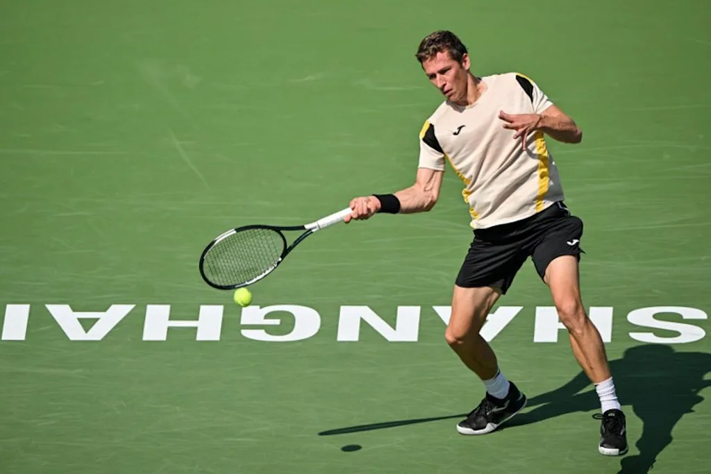 Belgium's Kimmer Coppejans hits a return to Greece's Stefanos Tsitsipas during their men's singles match at the Shanghai Masters tennis tournament in Shanghai on October 8, 2026.  Hector RETAMAL / AFP