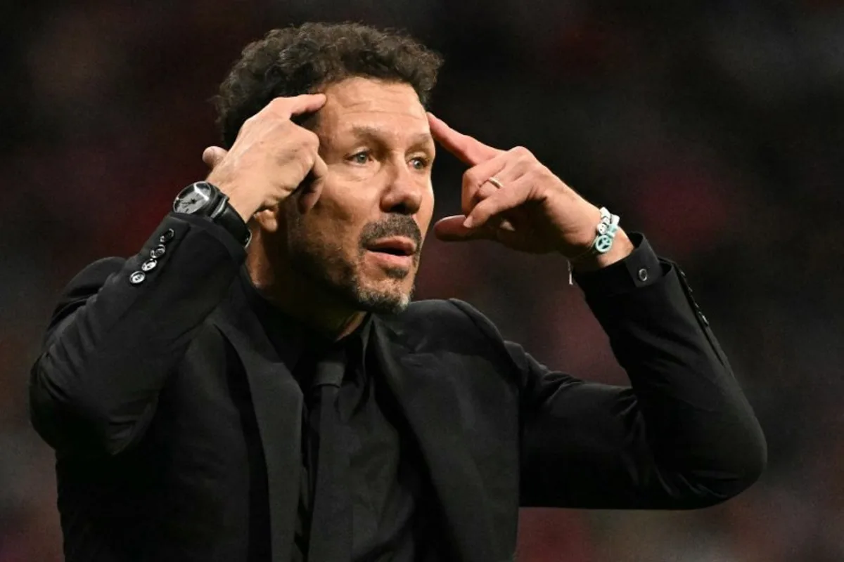 Atletico Madrid's Argentine coach Diego Simeone asks the supporters to stop sending items on the pitch after Brazilian defender #03 Eder Militao scored his team's first goal during the Spanish league football match between Club Atletico de Madrid and Real Madrid CF at the Metropolitano stadium in Madrid on September 29, 2024.  JAVIER SORIANO / AFP