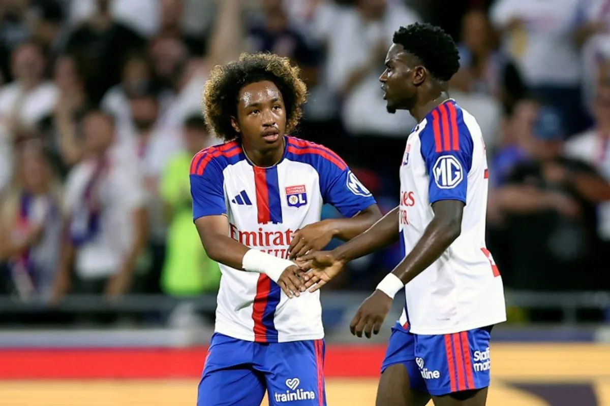 Lyon's Ghanaian forward #7 Ernest Nuamah (R) celebrates with Lyon's Belgian forward #11 Malick Fofana (C) after scoring his team's first goal during the UEFA Champions League third qualifying round - second leg football match between Olympique Lyonnais (OL) and Sparta Prague at Groupama Stadium in Decines-Charpieu, central-eastern France on August 11, 2026. Alex MARTIN / AFP