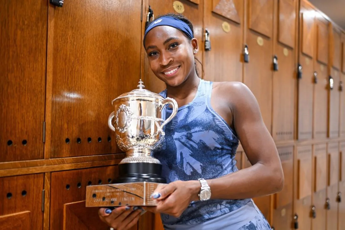 In this handout photograph taken and released on June 7, 2025 by French Tennis Federation (FFT) US Coco Gauff poses with her trophy at the locker room, after winning the women's singles final match against Belarus' Aryna Sabalenka on day 14 of the French Open tennis tournament at the Roland-Garros Complex in Paris. Corinne DUBREUIL / French Tennis Federation -FFT / AFP