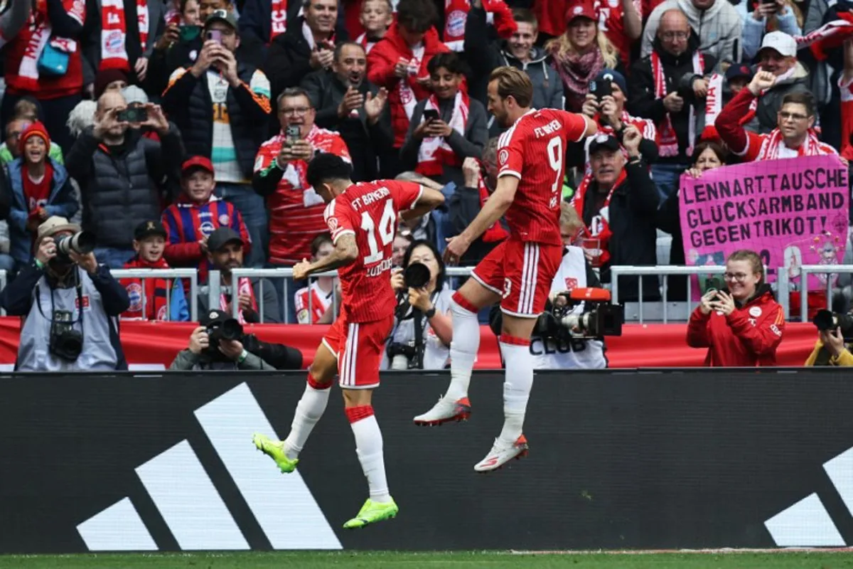 Bayern Munich's English forward #09 Harry Kane (R) jumps to celebrate scoring the opening 1-0 goal during the German first division Bundesliga football match between FC Bayern Munich and FC Cologne in Munich, southern Germany, on May 16, 2026. Alexandra BEIER / AFP