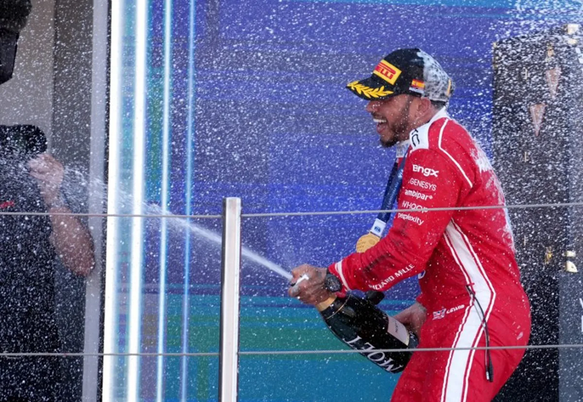 Ferrari's British driver Lewis Hamilton celebrates on the podium after winning the Catalonia Formula One Grand Prix at the Circuit de Catalunya in Montmelo, on the outskirts of Barcelona, on June 14, 2026. Manaure QUINTERO / AFP