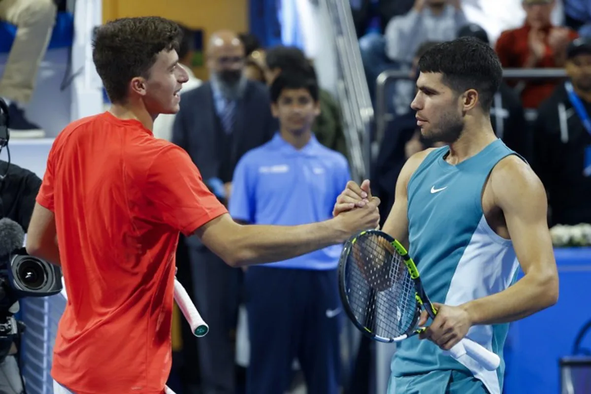 Spain's Carlos Alcaraz (R) shakes hands with Italy's Luca Nardi after their men's singles match at the ATP Qatar Open tennis tournament in Doha on February 19, 2025.  KARIM JAAFAR / AFP