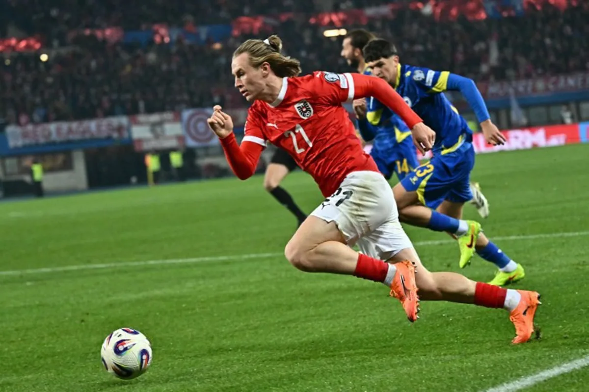 Austria's midfielder #21 Patrick Wimmer and Bosnia-Herzegovina's defender #23 Arjan Malic vie for the ball during the FIFA World Cup 2026 European qualification Group H football match between Austria and Bosnia and Herzegovina, in Vienna on November 18, 2025.  Joe Klamar / AFP