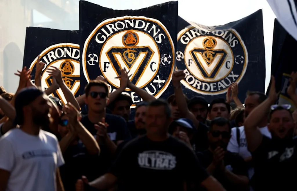 Supporters of French 'Nationale 2' fourth-tier club FC Girondins de Bordeaux wave the club's flags during a protest ahead of a hearing at the Direction Nationale du Controle de Gestion - DNGG, French football financial watchdog, following the six-time French champions' exclusion from national competitions, in Bordeaux, southwestern France July 19, 2026. Unless club officials secure a solution, Girondins de Bordeaux, also three-time French Cup winners, will be relegated to regional-level football following the DNCG's decision. ROMAIN PERROCHEAU / AFP