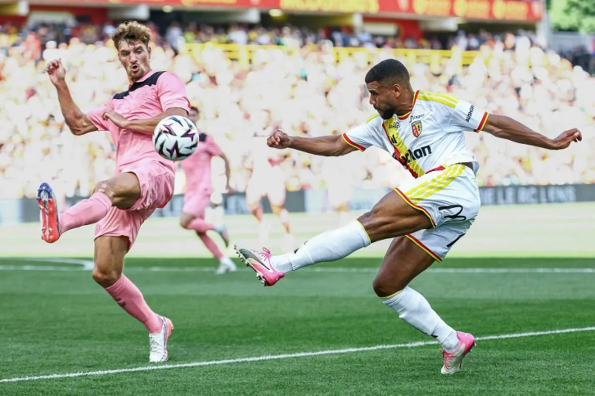 Lens' French defender Matthieu Udol (R) kicks the ball next to Sunderland's Belgian defender Thomas Meunier during a friendly football match between RC Lens and AFC Sunderland at the Bollaert-Delelis Stadium in Lens, northern France, on August 8, 2026. Sameer Al-DOUMY / AFP