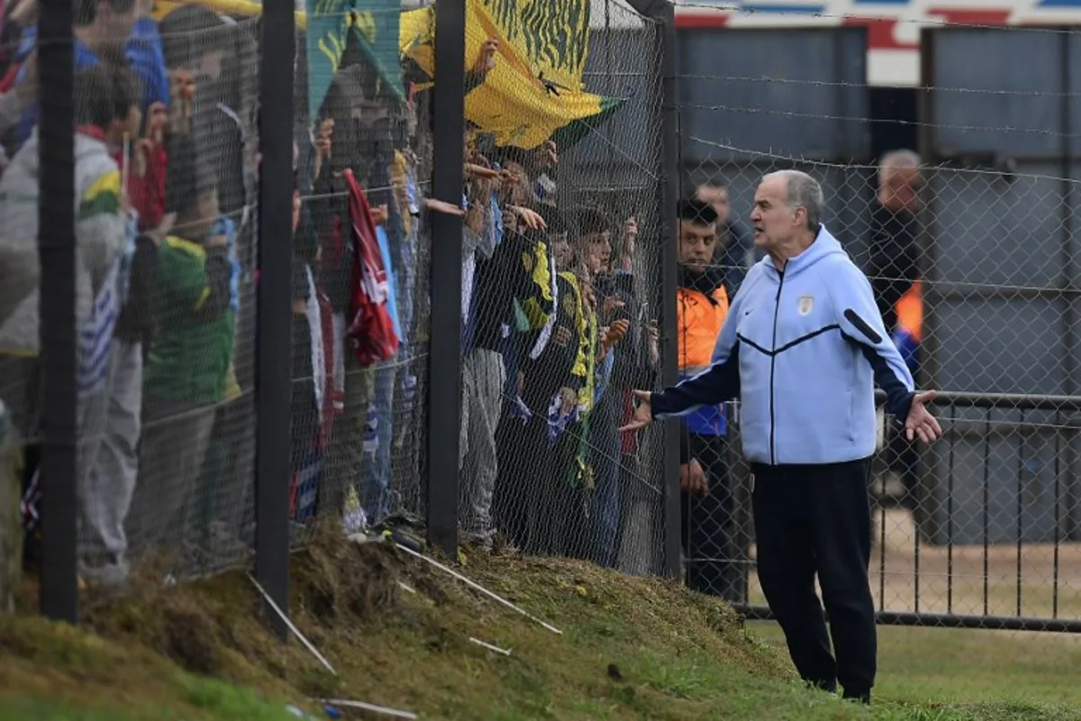 Uruguay's fnational football team coach, Argentinian Marcelo Bielsa, greets fans during a farewell activity with children ahead of the departure of the squad for the FIFA World Cup 2026, at the Tito Lopez Lopez stadium in Pando, Canelones department, Uruguay on June 5, 2026.  Dante FERNANDEZ / AFP