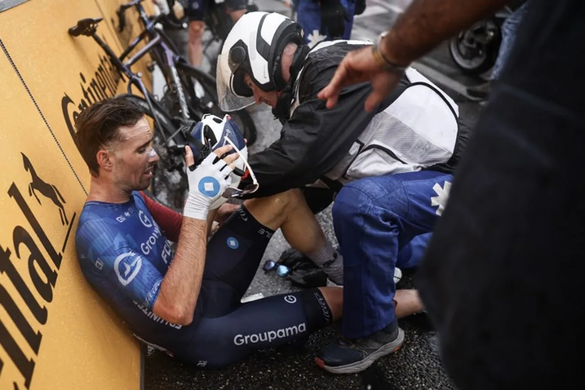 Groupama - FDJ team's French rider Cyril Barthe receives medical assistance after a mass crash metres from the finish line of the 112th edition of the Tour de France cycling race, 160.4 km between Bollene and Valence, southern France, on July 23, 2025. Anne-Christine POUJOULAT / AFP