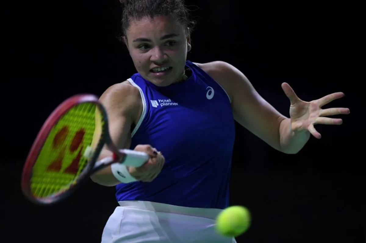 Italy's Jasmine Paolini returns a ball to Poland's Iga Swiatek during their semi-finals singles tennis match between Poland and Italy at the Billie Jean King Cup Finals at the Palacio de Deportes Jose Maria Martin Carpena arena in Malaga, southern Spain, on November 18, 2024.   JORGE GUERRERO / AFP