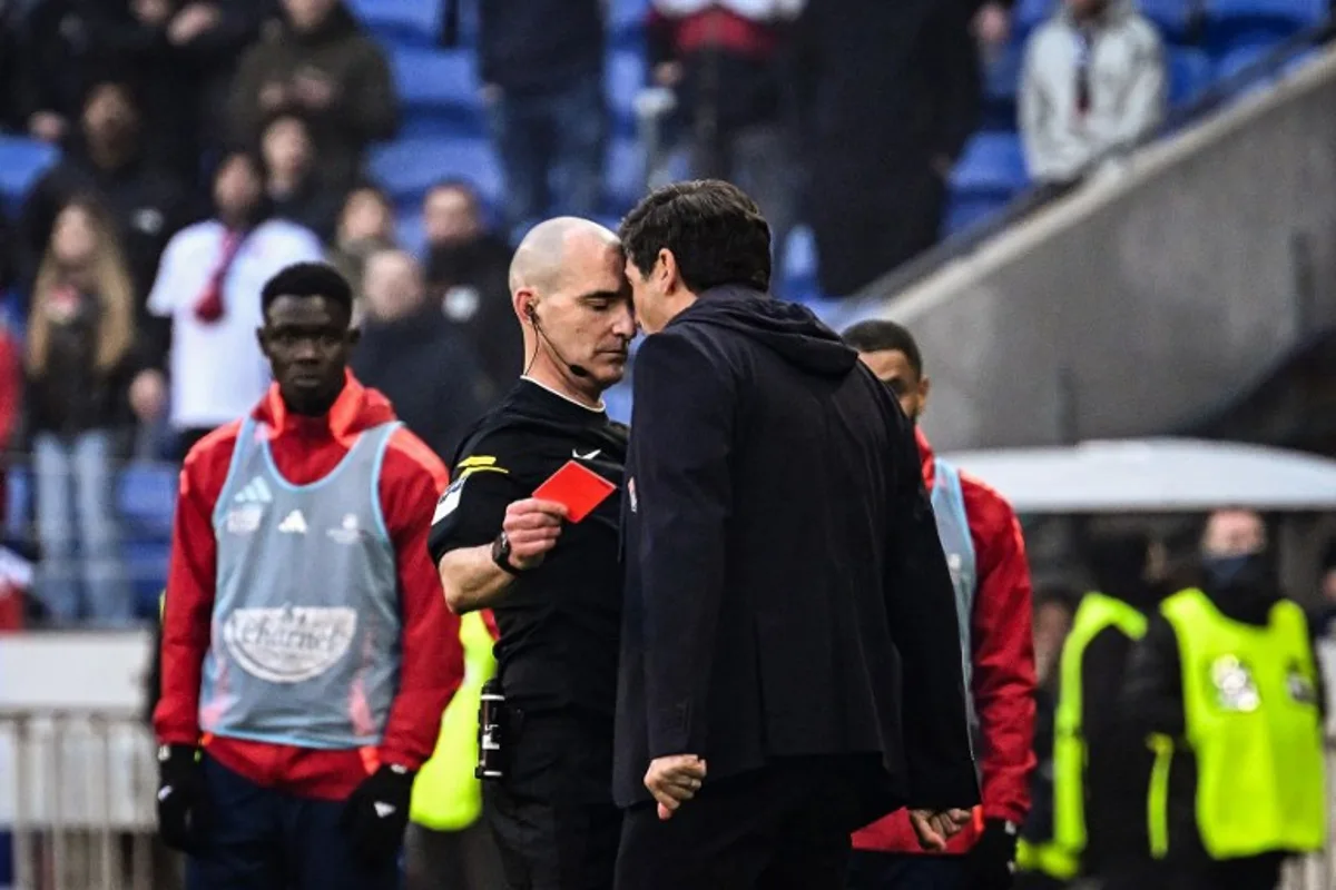 Lyon's Portuguese head coach Paulo Fonseca (R) yells at French referee Benoit Millot (L) after receiving a red card during the French L1 football match between Olympique Lyonnais (OL) and Stade Brestois 29 (Brest) at the Parc Olympique lyonnais in Decines-Charpieu, central-eastern France on March 2, 2025.  JEFF PACHOUD / AFP