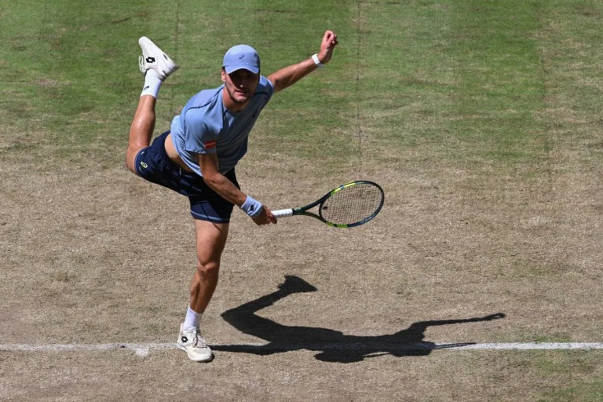 Belgium's Raphael Collignon returns the ball to Germany's Alexander Zverev during their men's singles quarter-final match of the Halle Open ATP tennis tournament in Halle, western Germany, on June 19, 2026.  CARMEN JASPERSEN / AFP