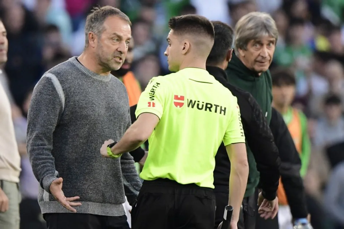 Barcelona's German coach Hans-Dieter Flick (L) reacts to receiving a red card during the Spanish league football match between Real Betis and FC Barcelona at the Benito Villamarin stadium in Seville on December 7, 2024.  CRISTINA QUICLER / AFP