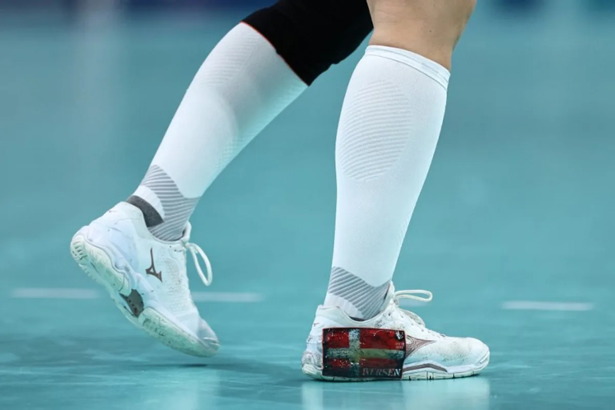 This photogrph shows the Denmak's national flag on the sneaker of Denmark's pivot #05 Sarah Aaberg Iversen during the women's Bronze Medal handball match between Denmark vs Sweden of the Paris 2024 Olympic Games, at the Pierre-Mauroy stadium in Villeneuve-d'Ascq, northern France, on August 10, 2024. Sameer Al-Doumy / AFP