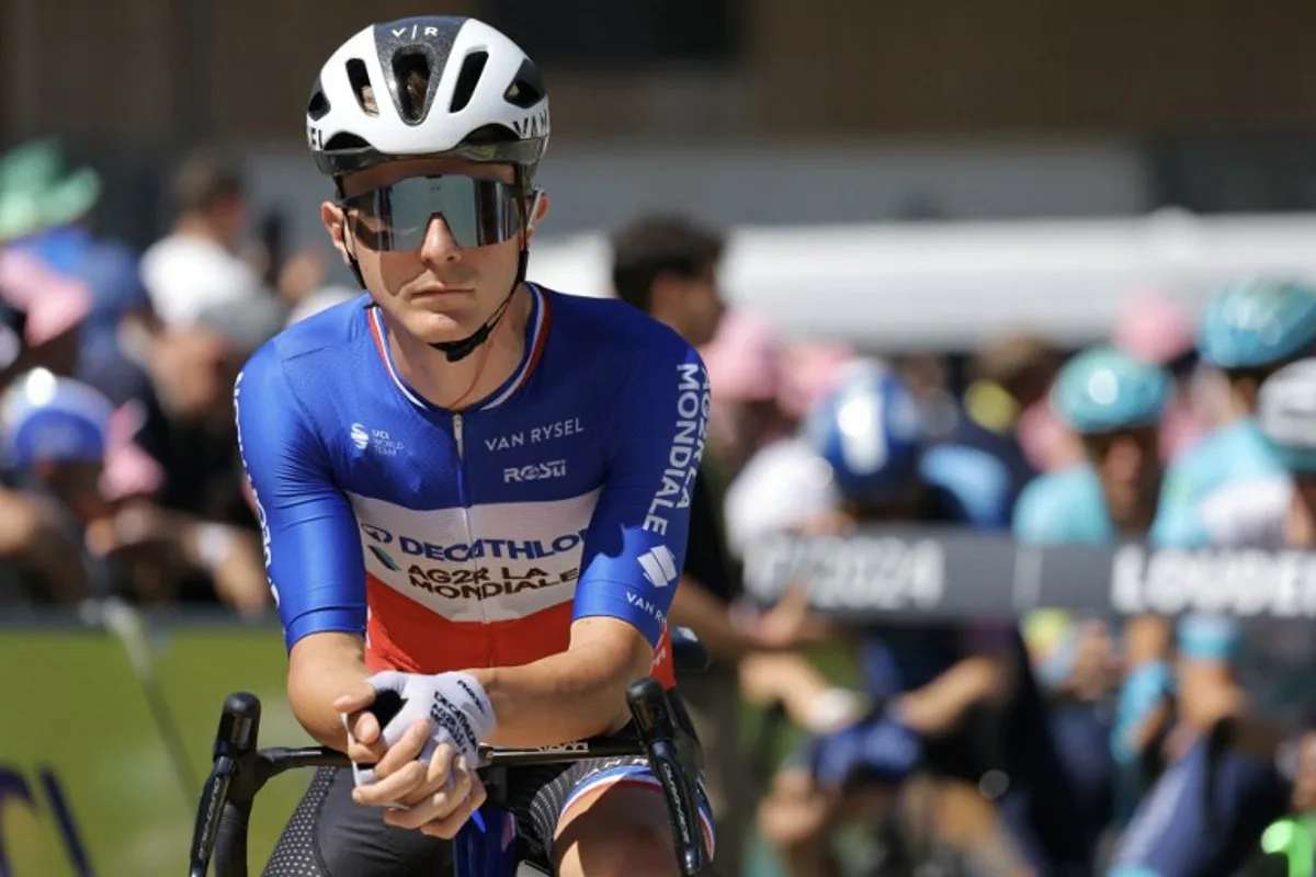 Decathlon AG2R La Mondiale Team's French rider Paul Lapeira looks on as he awaits the start of the 15th stage of the 111th edition of the Tour de France cycling race, 197,7 km between Loudenvielle and Plateau de Beille, in the Pyrenees mountains, southwestern France, on July 14, 2024.  Thomas SAMSON / AFP