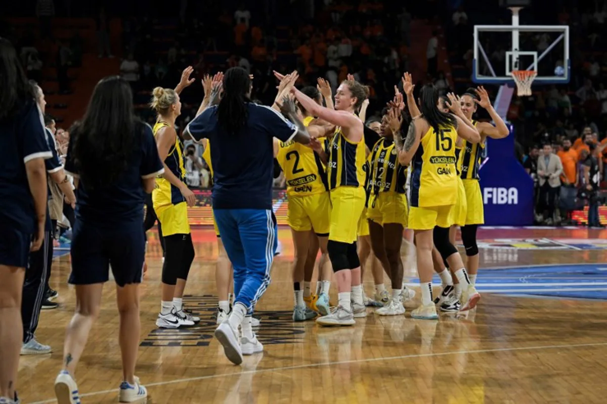 Fenerbahce's Belgian forward #11 Emma Meesseman (C) celebrates with her teammates after winning the women's FIBA Euroleague basketball semifinal match between Fenerbahce Alagoz Holding and Cukurova Basketbol Mersin at Servet Tazegul Spor Salonu arena, in Mersin, on April 12, 2024.  OZAN KOSE / AFP