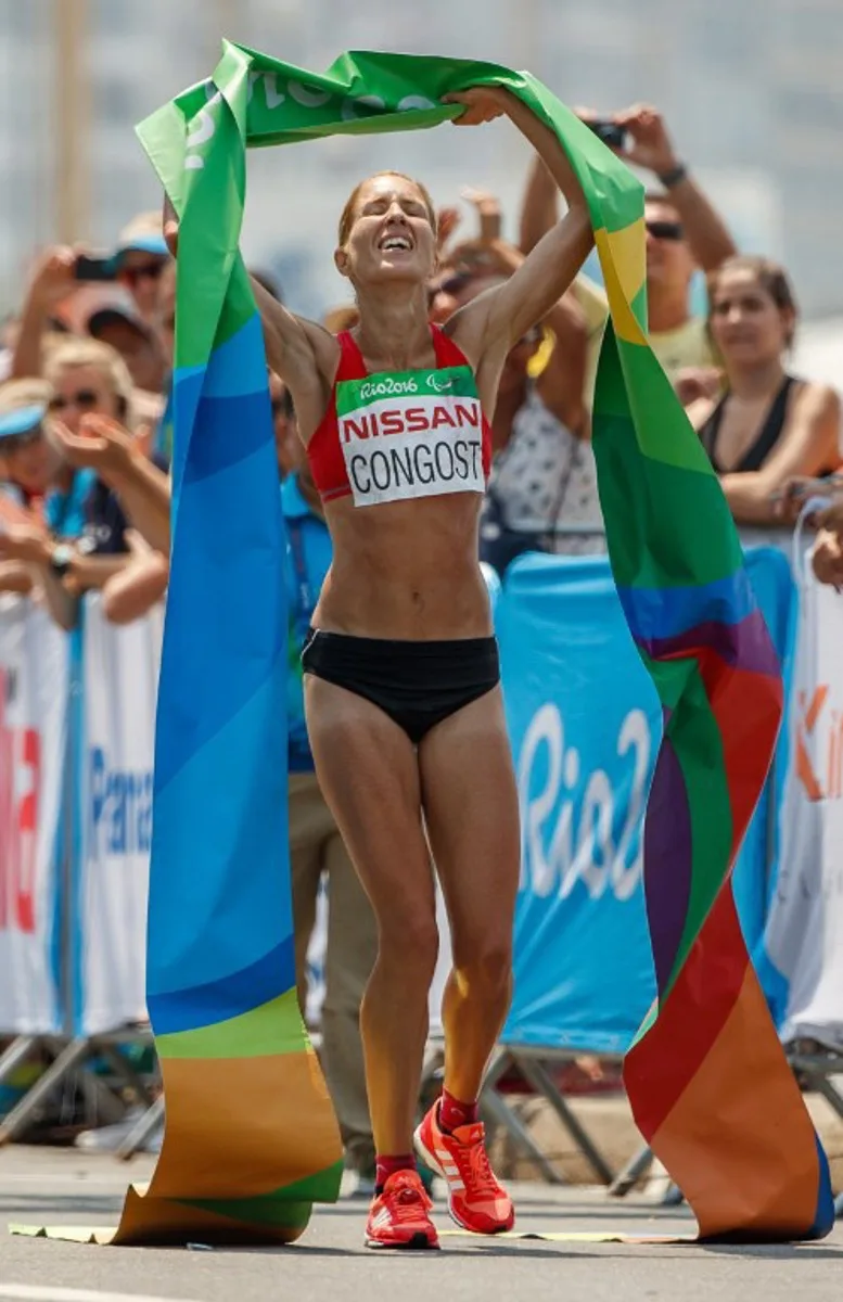 Handout picture released by OIS/OIC showing Elena Congost Mohedano of Spain celebrating after winning the gold medal in the Women's T12 Marathon at Fort Copacabana during the Paralympic Games in Rio de Janeiro, Brazil on September 18, 2016.  Al TIELEMANS / OIS/IOC / AFP