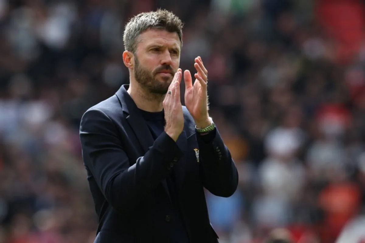 Manchester United's English Interim head coach Michael Carrick applauds fans on the pitch after their final home appearance in the English Premier League football match between Manchester United and Nottingham Forest at Old Trafford in Manchester, north west England, on May 17, 2026. United won the game 3-2. Darren Staples / AFP