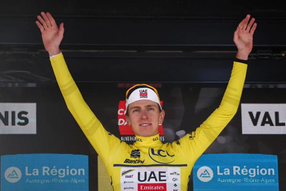 UAE Team Emirates XRG's Slovenian rider Tadej Pogačar wearing the overall leader's yellow jersey celebrates winning the overall race on the podium of the 8th and final stage of the 77th edition of the Criterium du Dauphine cycling race, 133,3 km between Val-d'Arc and Val-Cenis - Plateau du Mont Cenis, on June 15, 2025. Anne-Christine POUJOULAT / AFP