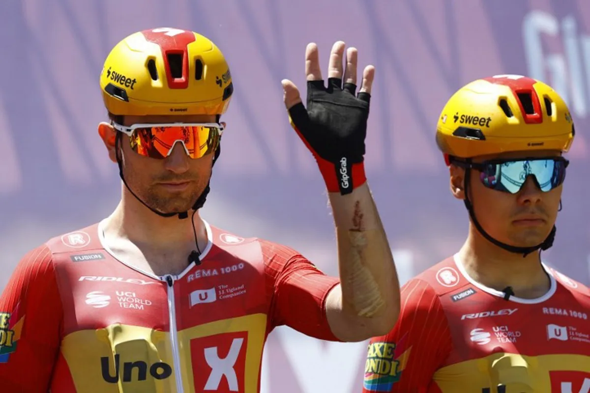 Uno X Mobility Norwegian rider Erlend Blikra (L) waves during the presentation prior the 4th stage of the Giro d'Italia 2026 - Tour of Italy cycling race between Catanzaro and Cosenza, Italy, on May 12, 2026. Luca Bettini / AFP