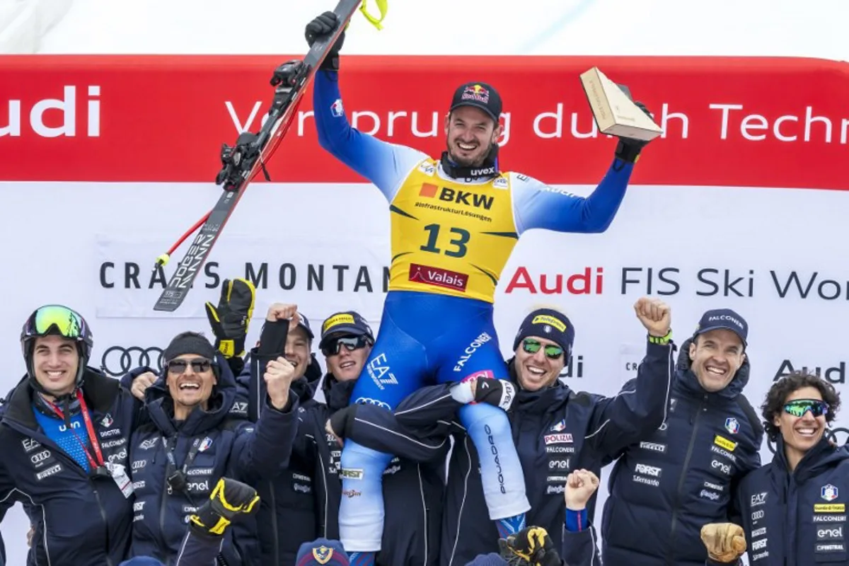 Third-placed Italy's Dominik Paris celebrates with his staff after the men's Super G event at the FIS Alpine Skiing World Cup in Crans-Montana on February 23, 2025.  Fabrice COFFRINI / AFP