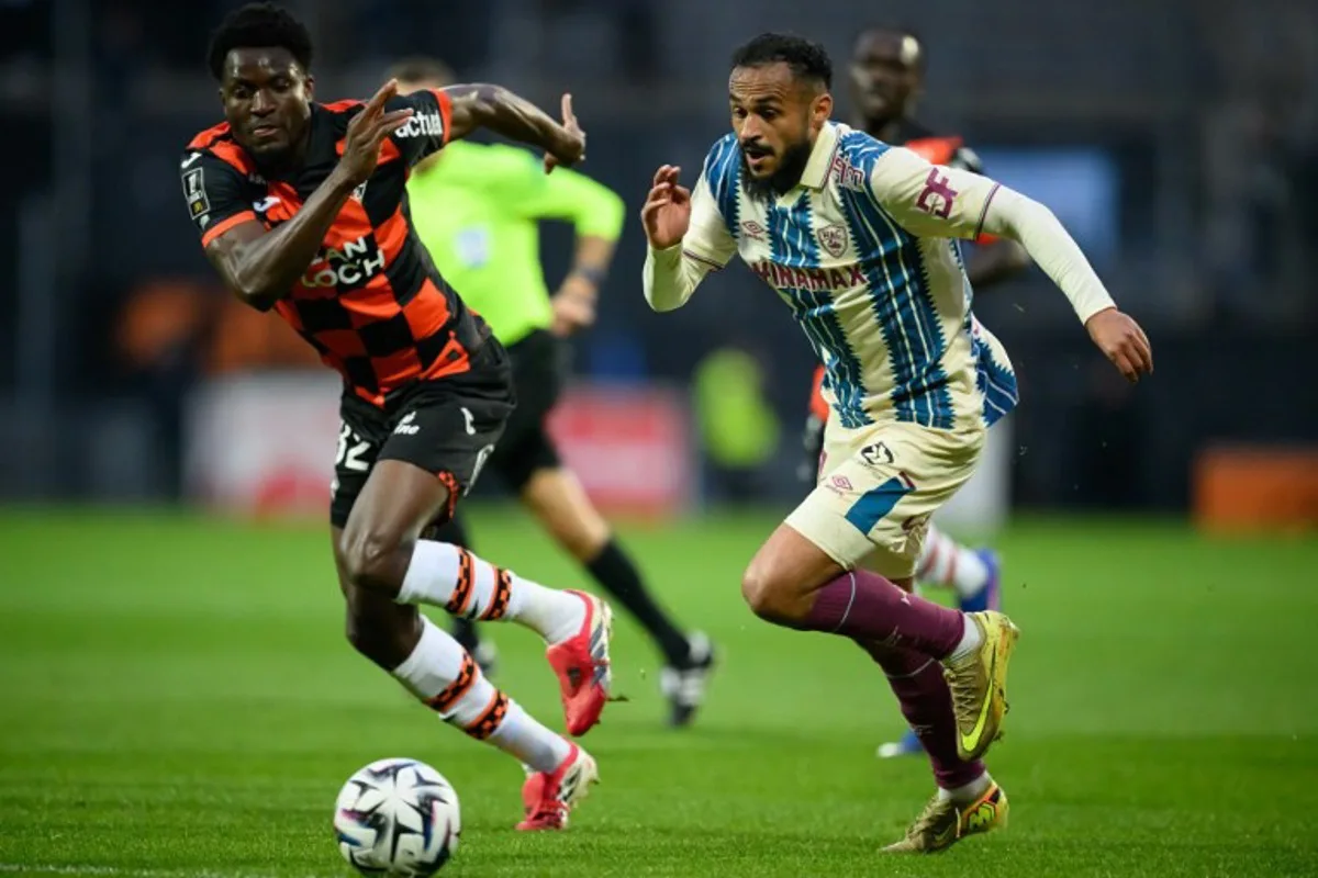 Lorient's Ghanaian defender #32 Nathaniel Adjei fights for the ball with Le Havre's Moroccan midfielder #17 Sofiane Boufal during the French L1 football match between FC Lorient and Le Havre Athletic Club at Yves-Allainmat stadium in Lorient, western France on May 17, 2026. Loic VENANCE / AFP