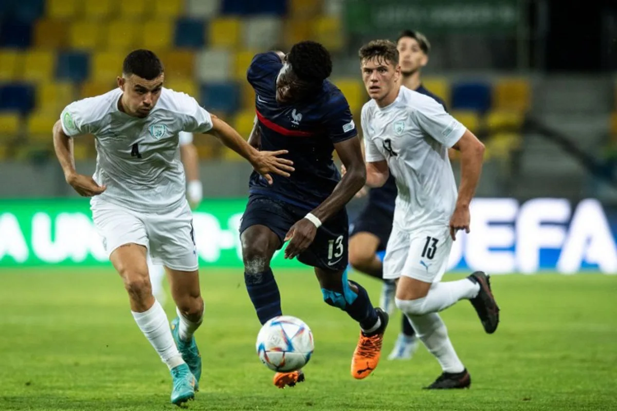 (L-R) Israel's defender Stav Lemkin, France's Ange-Yoan Bonny and Israel's defender Ilay Feingold vie for the ball during the UEFA Under-19 European Championship semi-final football match between France and Israel at the DAC Arena in Dunajska Streda, Slovakia on June 28, 2022. VLADIMIR SIMICEK / AFP